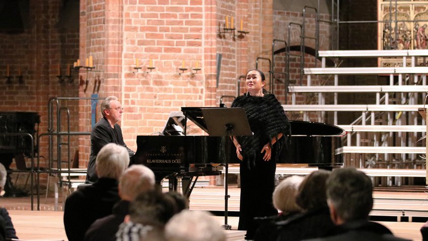 Sängerin und Pianist musizieren in der vollen Marktkirche
