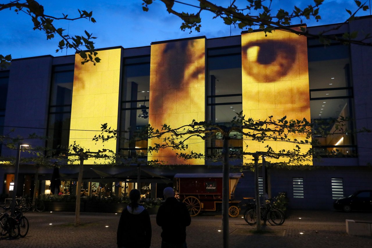 Lichtinstallation eines Gesichts auf der Plenarsaalfassade