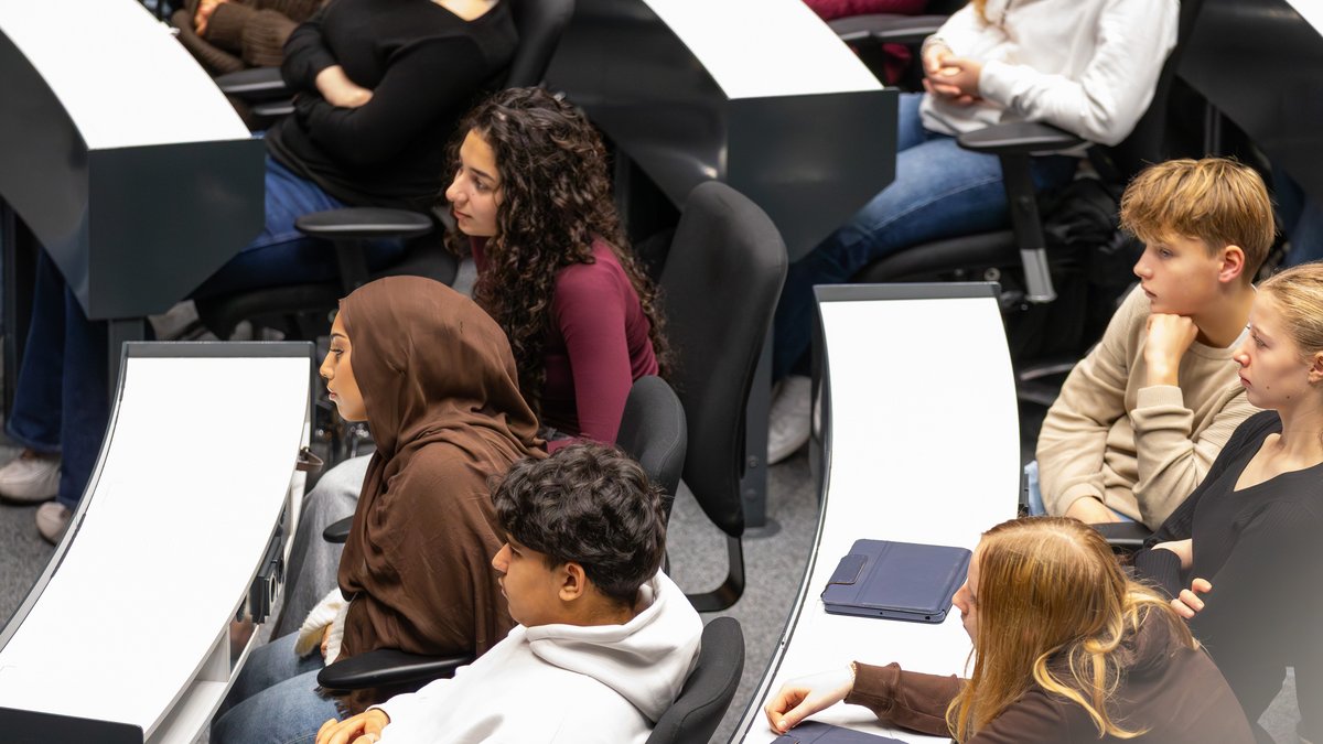 Schülerinnen und Schüler hören konzentriert zu.