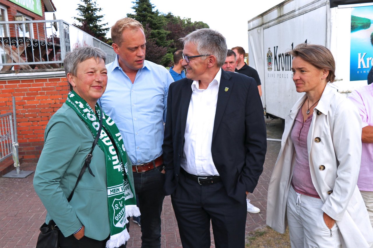 Landtagspräsidentin Naber mit drei weiteren Personen, sie lächelt und trägt einen grünen SV Ostfrisia Moordorf Schal.