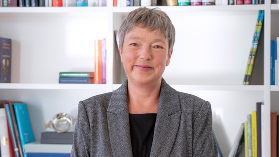 Landtagspräsidentin Hanna Naber vor einem Bücherregal.