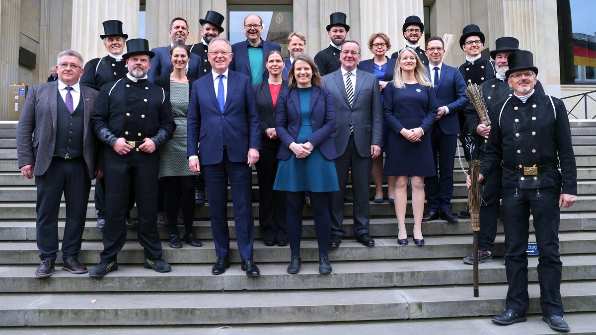 The new government in front of the parliament building with a group of chimney sweeps, who came to wish the government good luck with their work.
