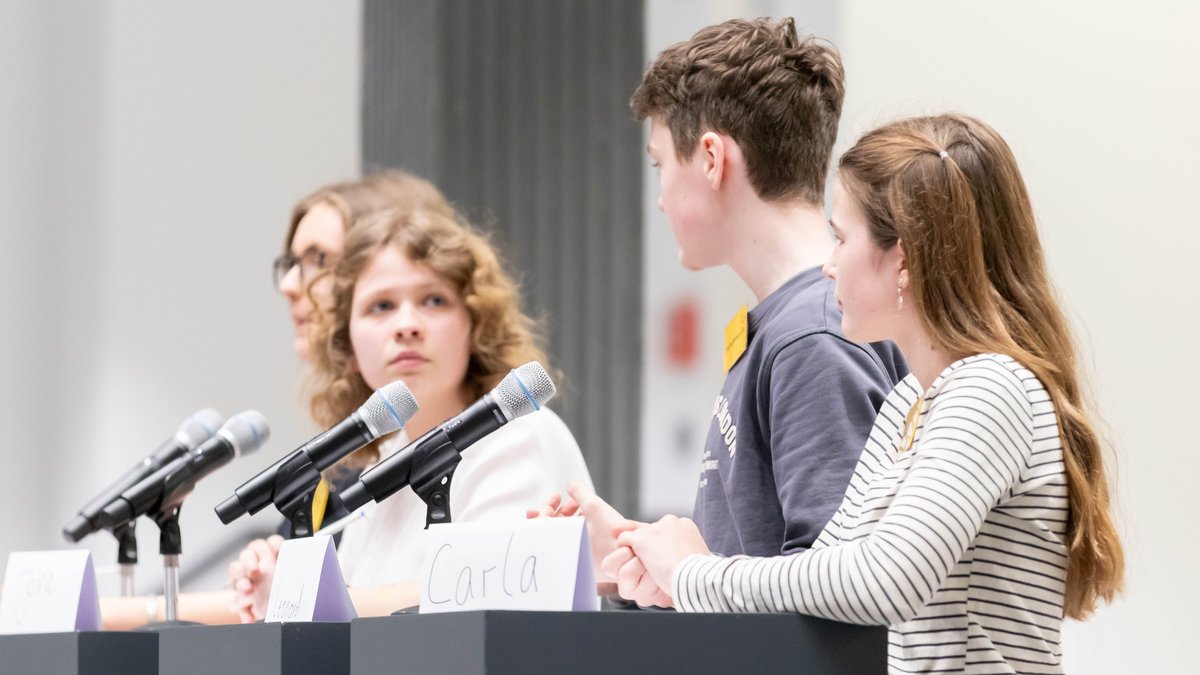 Teilnehmer während der Diskussion an den Mikofonen