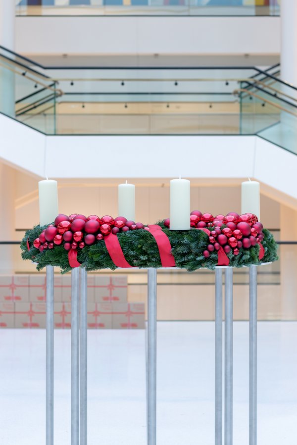 Adventskranz mit Tanne, roten schleifen und weißen Kerzen