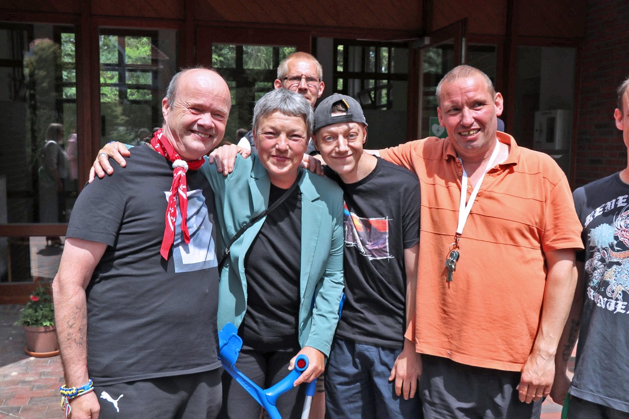 Gruppenfoto von Landtagspräsidentin Naber mit drei Männern, sie alle lächeln und legen sich die Arme um die Schultern.
