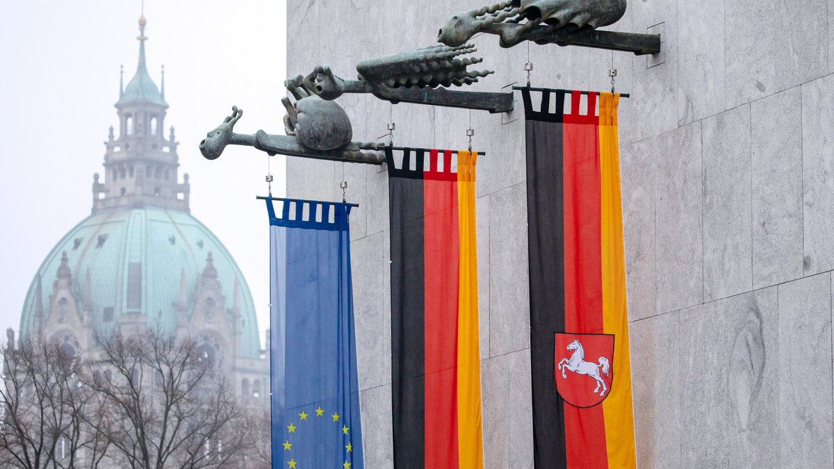 Klick auf das Bild öffnet eine vergrößerte Ansicht in einem Overlay. Zum Schließen des Overlays die ESC-Taste drücken. Fahnenträger mit Europa-, Deutschland- und Niedersachsenflagge.