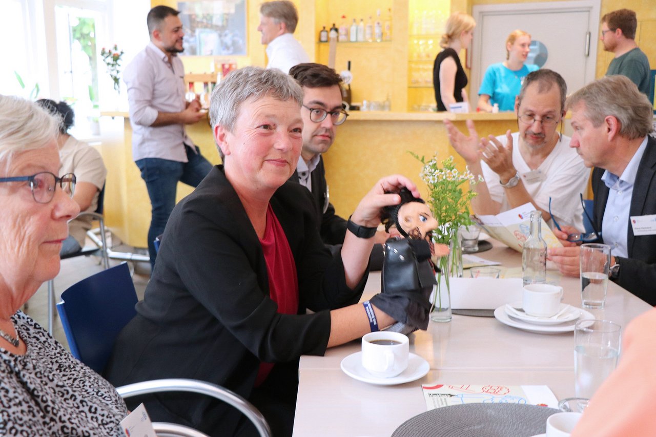 Bild: © Niedersächsischer Landtag Landtagspräsidentin Naber mit anderen Personen an einem Tisch in lockerer Atmosphäre.