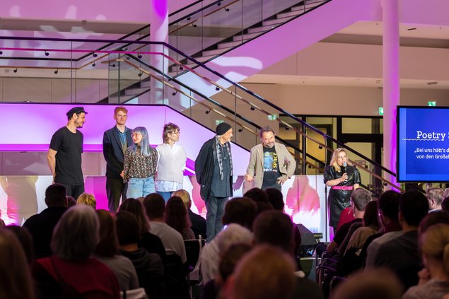 Poetry Slam 2021 im Landtag Bild: © Niedersächsischer Landtag Menschen haben sich auf der Bühne vor dem Publikum versammelt.