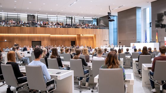 Viele junge Menschen im Plenarsaal und auf der Besuchertribüne.
