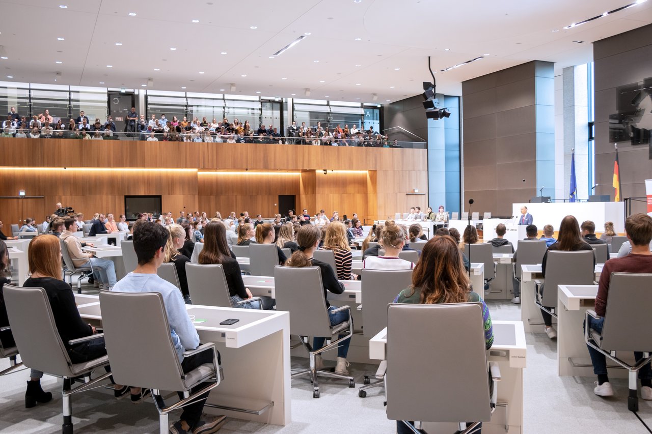 Viele junge Menschen im Plenarsaal und auf der Besuchertribüne.