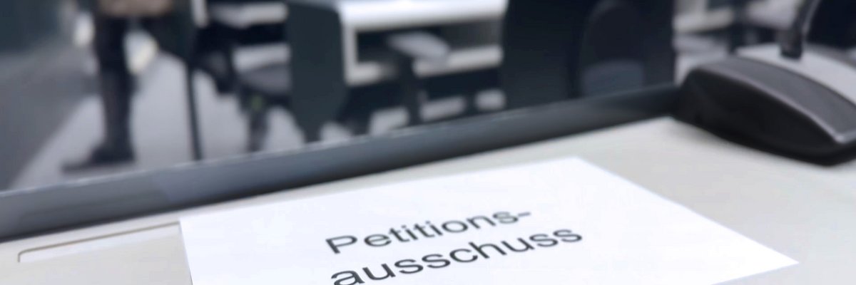 Blatt mit der Aufschrift "Petitionsausschuss" auf einem Tisch im Forum des Landtages.