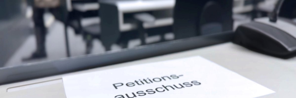 Blatt mit der Aufschrift "Petitionsausschuss" auf einem Tisch im Forum des Landtages.