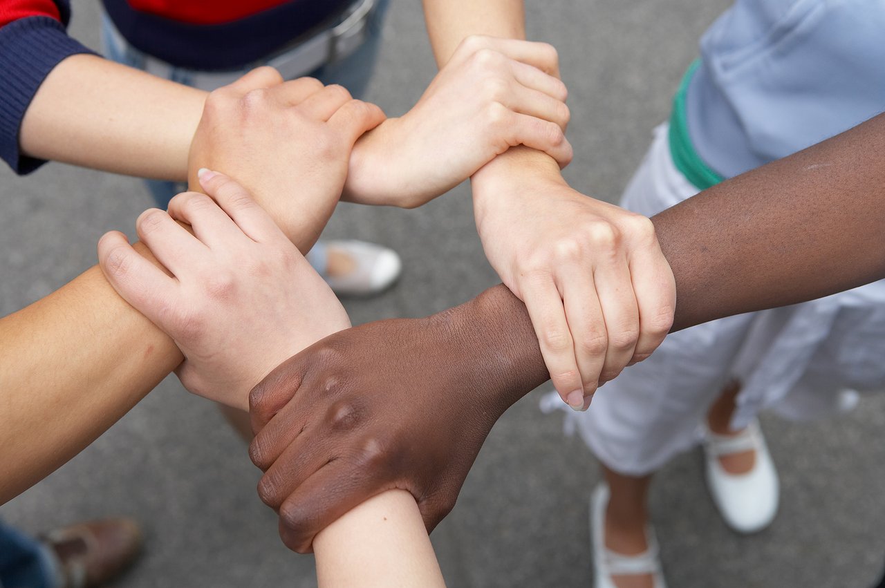 Menschen mit verschiedenen Hautfarben halten einander fest