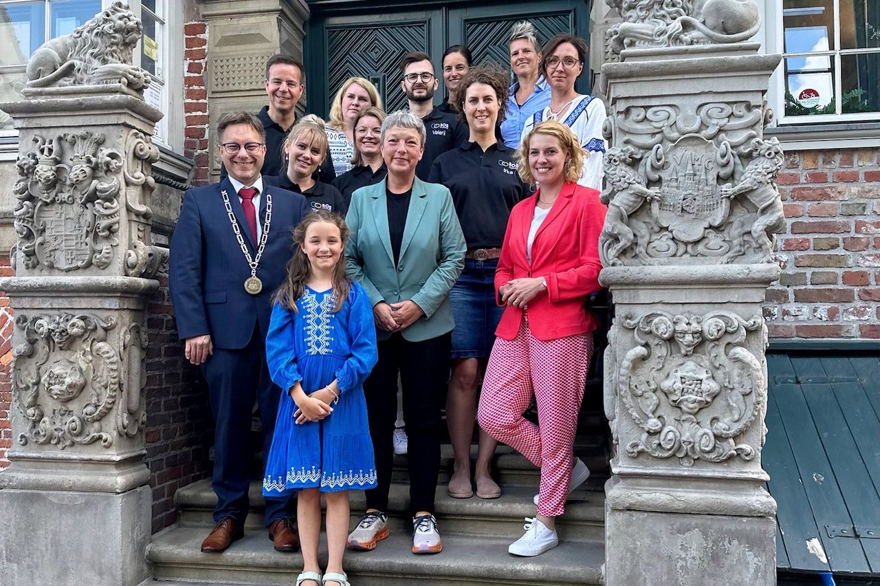 Bild: © Niedersächsischer Landtag Gruppenfoto vor dem Rathaus von Jever, zu sehen sind Präsidentin Naber mit Personen vom Verein SOS Ukraine e.V. sowie Bürgermeister Albers.