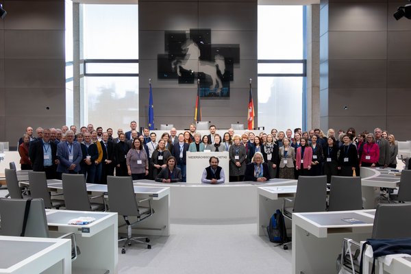 Gruppenfoto der Teilnehmenden des Verbandstages der Parlaments- und Verhandlungsstenografen mit Landtagspräsidentin Hanna Naber im Plenarsaal