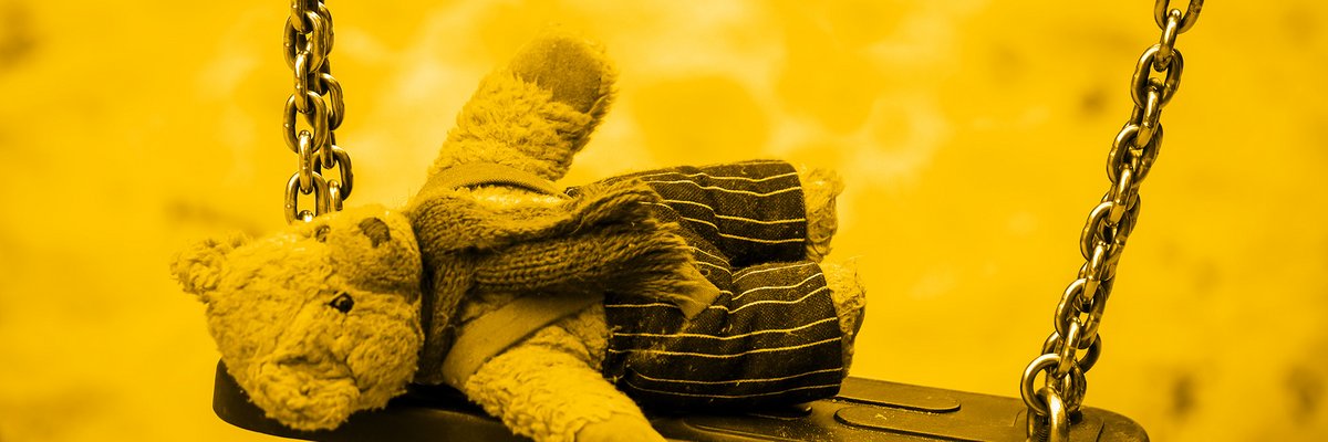 Stoffteddy liegend auf einer Schaukel