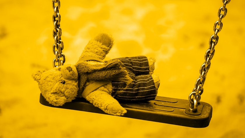 Stoffteddy liegend auf einer Schaukel