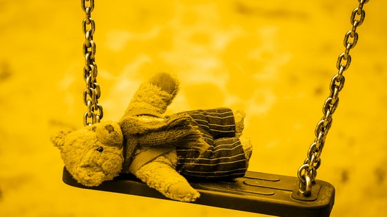 Stoffteddy liegend auf einer Schaukel