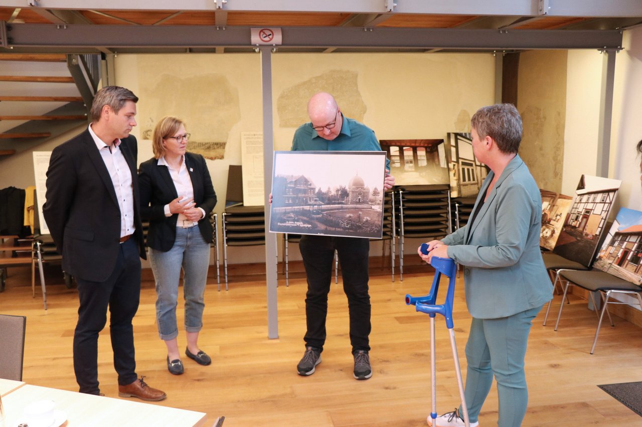 Bild: © Niedersächsischer Landtag Landtagspräsidentin Naber während eines Besuchs der Synagoge Einbeck, ein Vertreter der Synagoge zeigt ein Bild; links zwei weitere Personen.