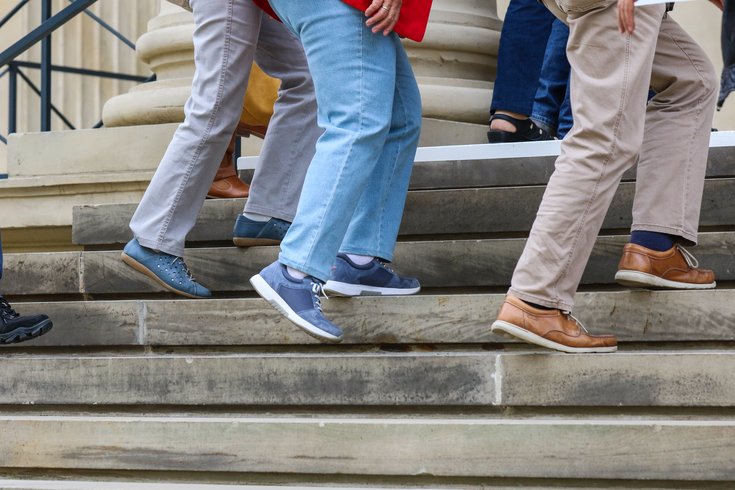 Besucher am Portikus, hier nur zu sehen, die Beine und Füße auf der Treppe