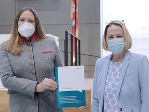 Bild: © Niedersächsischer Landtag Die Vorsitzende der Enquetekommission Petra Joumaah (re.) überreicht den Abschlussbericht der Kommission an Landtagspräsidentin Dr. Gabriele Andretta.