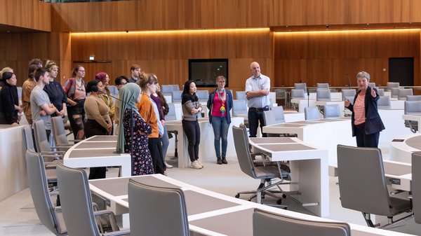 Bild: © Niedersächsischer Landtag Landtagspräsidentin Hanna Naber mit einer Gruppe von Studierenden der HAWK sowie deren Professorin und Professor im Plenarsaal.