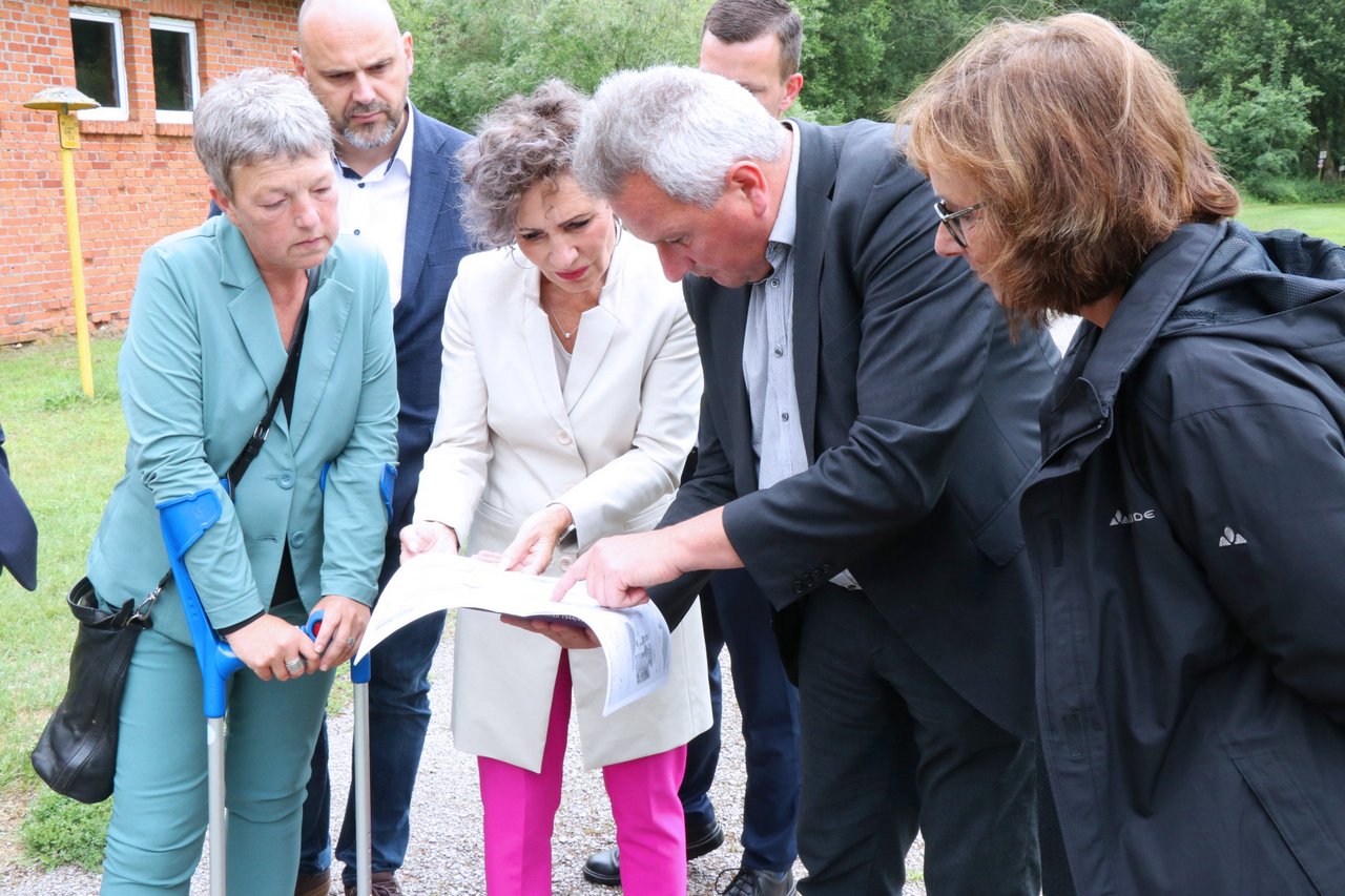 Landtagspräsidentin Naber (Niedersachsen) und Landtagspräsidentin Pommer (Thüringen) während ihres Besuches bei einer Gedenkstätte, sie beugen sich mit anderen Personen über eine Karte.