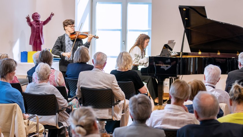 Ein Violinist und eine Pianistin spielen vor Publikum im Leibniz-Saal.