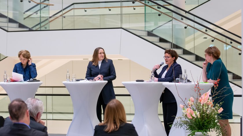 Die vier Teilnehmerinnen der Diskussion stehen an Stehtischen.