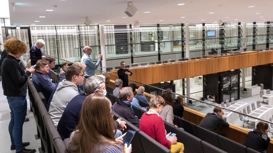 Menschen während einer Führung auf der Besuchertribüne