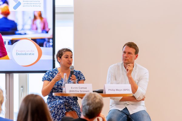 Klick auf das Bild öffnet eine vergrößerte Ansicht in einem Overlay. Zum Schließen des Overlays die ESC-Taste drücken. Evrim Camuz (links, Bündnis 90/Die Grünen) und Philipp Meyn (rechts, SPD) während der Abschlussdiskussion.'}