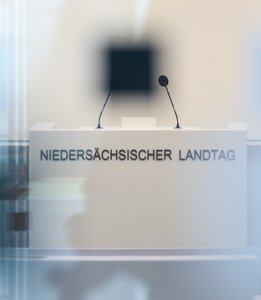 Blick durch Glasscheiben auf Rednerpult