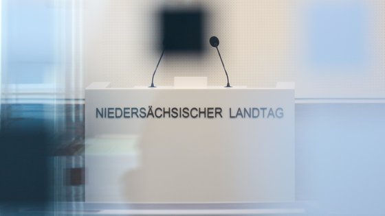 Blick durch Glasscheiben auf Rednerpult