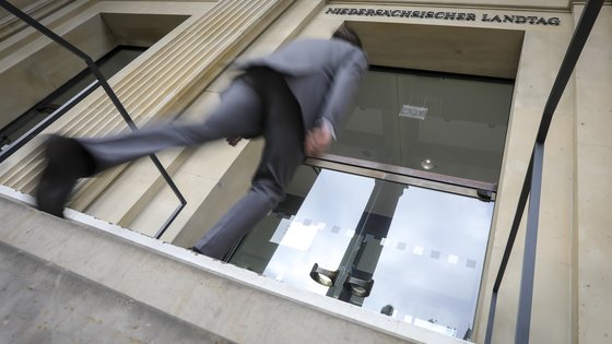 Mann steigt Treppen herauf, um Tür zu öffnen