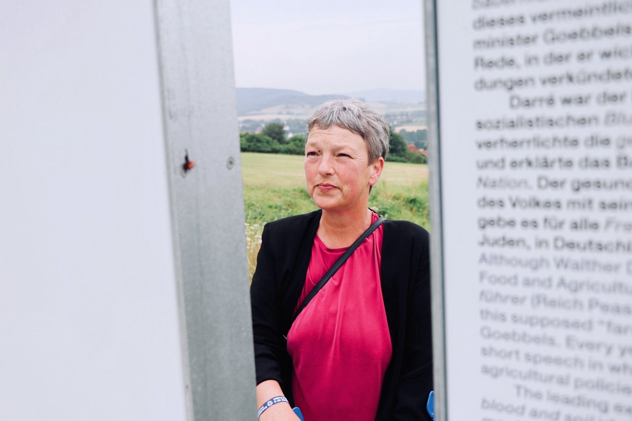 Bild: © Niedersächsischer Landtag Landtagspräsidentin Naber liest Informationen auf einem Aufsteller am Dokumentations- und Lernort Bückeberg.