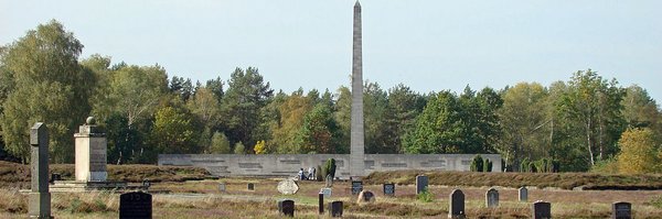 Bild: © Hajotthu, CC BY-SA 3.0, via Wikimedia Commons Friedhofsgelände KZ Bergen-Belsen mit Obelisk, Jüdischem Mahnmal, Massengräbern und symbolischen Grabsteinen.