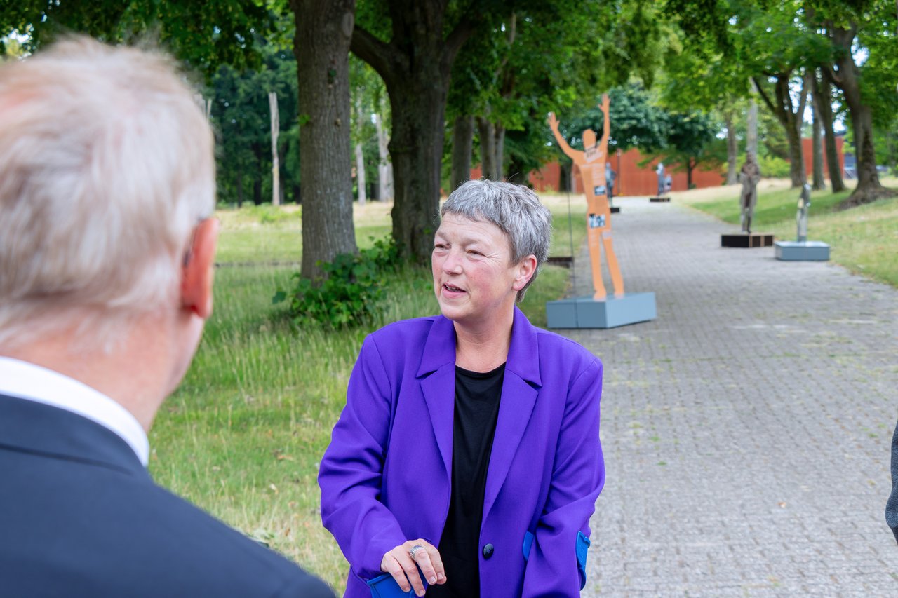 Landtagspräsidentin Naber im Freien, im Hintergrund ein Element der Gedenkstätte Esterwegen.