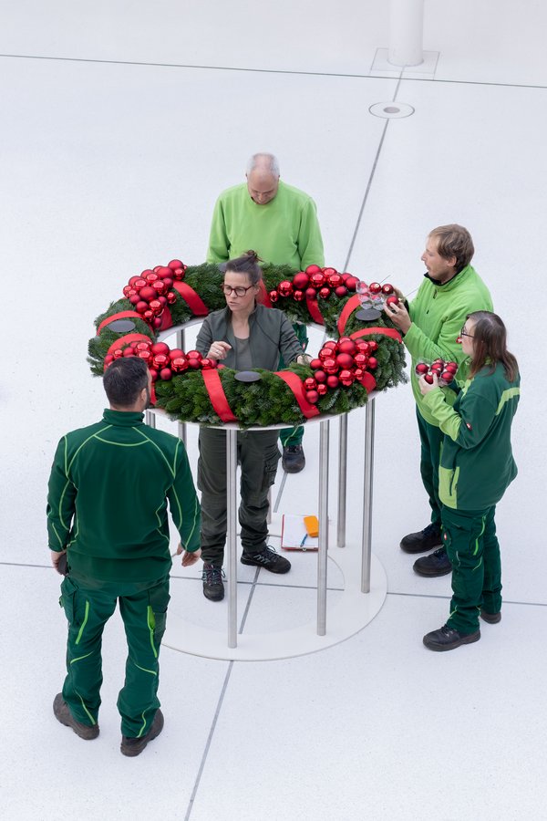 Mitarbeitende der Neu Erkeröder Stiftung bauen den Adventskranz auf