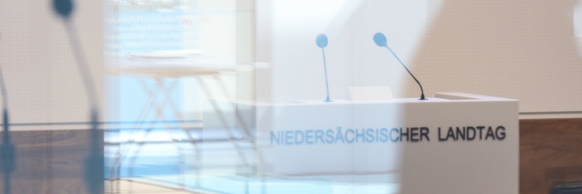 Durch die Glasscheiben des Plenarsaals fotografiertes Rednerpult