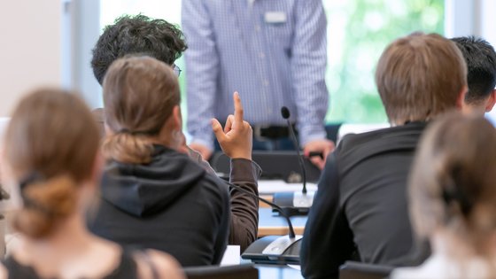Schülerinnen und Schüler während eines Workshops im Landtag. Eine Person meldet sich per Handzeichen.