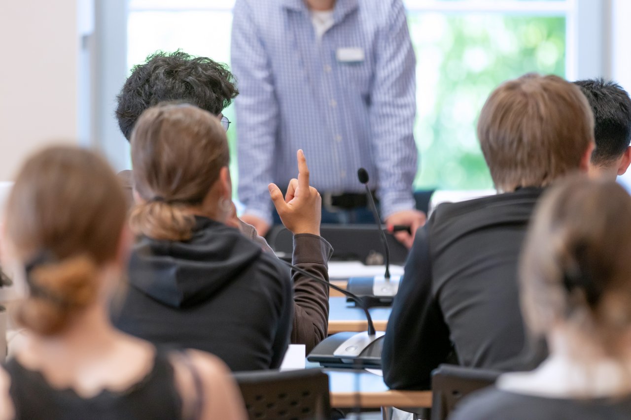 Schülerinnen und Schüler während eines Workshops im Landtag. Eine Person meldet sich per Handzeichen.