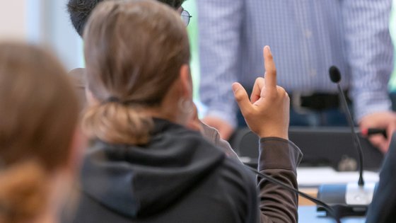 Schülerinnen und Schüler während eines Workshops im Landtag. Eine Person meldet sich per Handzeichen.