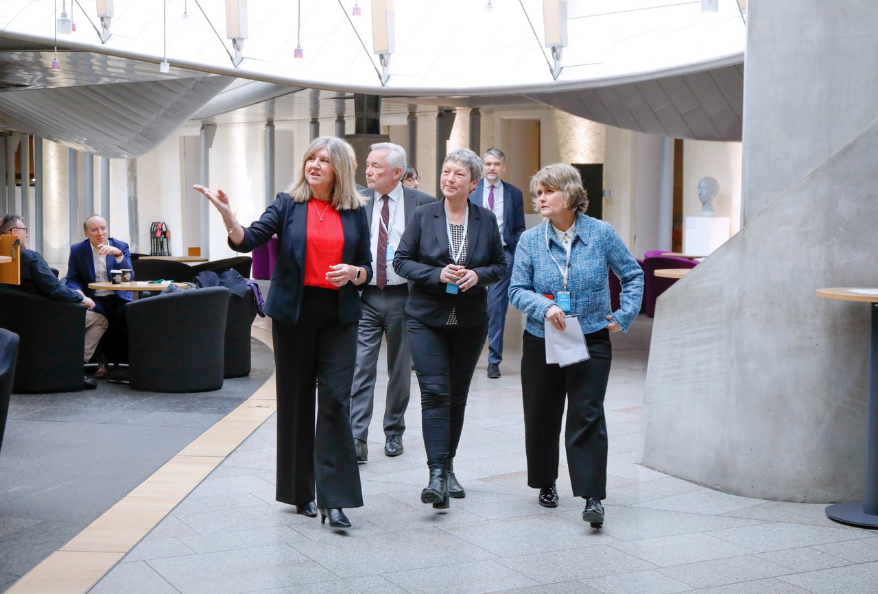 Presiding Officer Alison Johnstone führt die Gäste durch das Parlamentsgebäude.