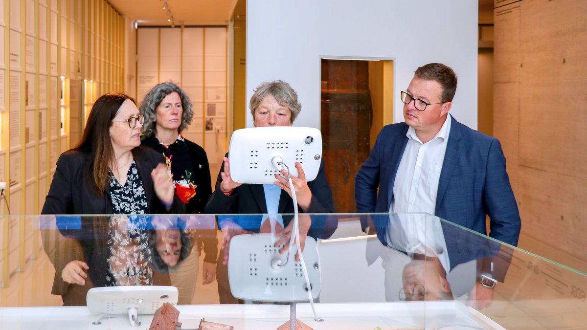 Landtagspräsidentin Hanna Naber in der Gedenkstätte. Sie bedient ein Tablet, das mit einem Stadtmodell verbunden ist. Neben ihr stehen der Wahlkreisabgeordnete Jan Schröder sowie zwei Damen von der Gedenkstätte.