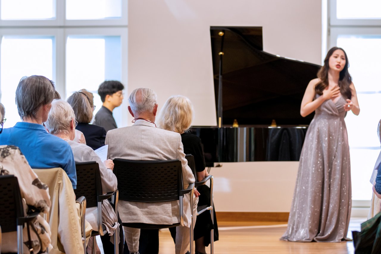 Eine Sängerin und ein Pianist spielen vor Publikum.