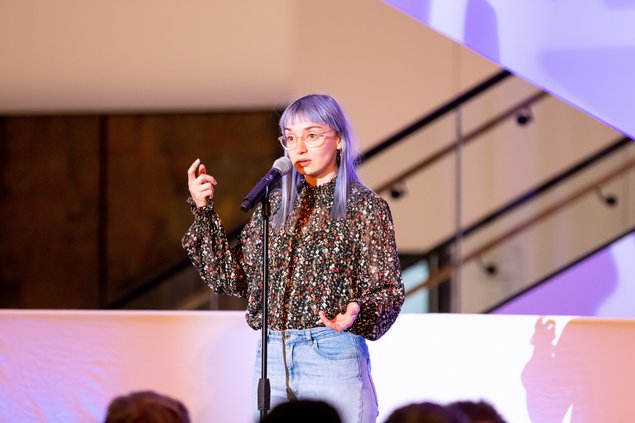 Poetry Slam 2021 im Landtag Bild: © Niedersächsischer Landtag Jule Weber vor gestikulierend vom dem Mikrofon.