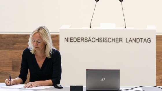 Eine Stenografin schreibt vor dem Rednerpult mit.