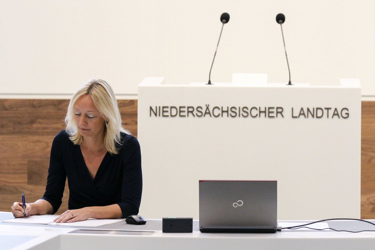 Bild: © Focke Strangmann Eine Stenografin schreibt vor dem Rednerpult mit.
