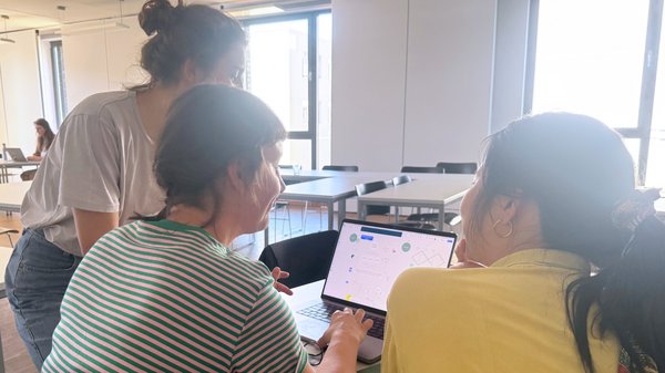 Bild: © Niedersächsischer Landtag Drei Studierende im Austausch an einem Notebook.