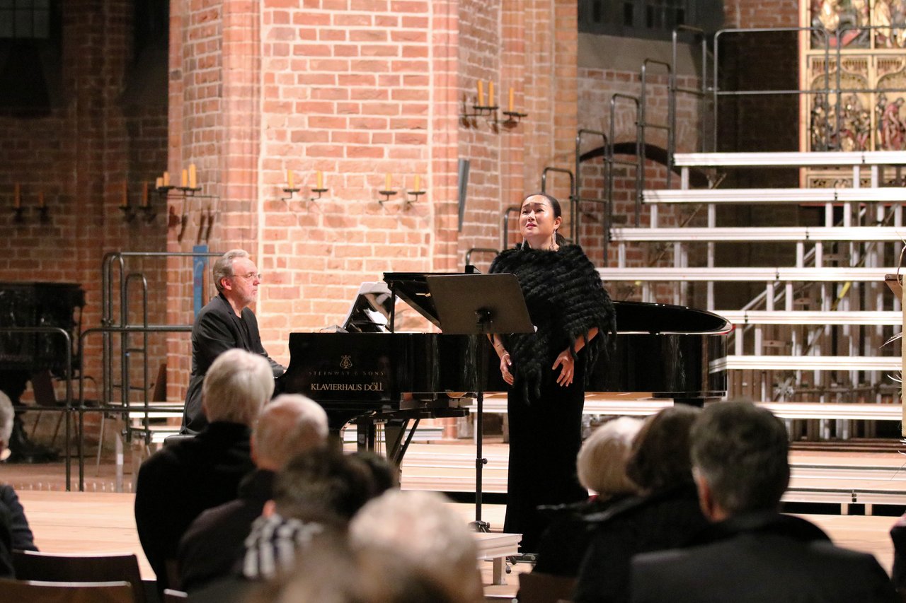 Sängerin und Pianist musizieren in der vollen Marktkirche